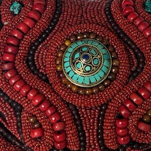 Meticulously beaded bag in
turquoise, red, black and coral.Handcrafted in Tibet.